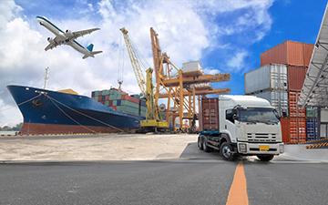 Cargo ship, truck, crane, and airplane flying in the sky